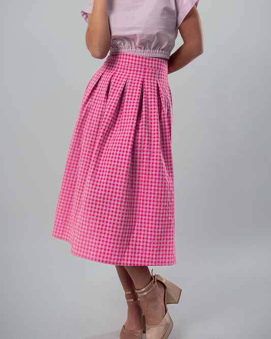 Pleated Skirt with Neon Pink and Mauve Gingham Print, Paired with a Crop Top Featuring an Elastic Waistband and Ruffled Neckline
